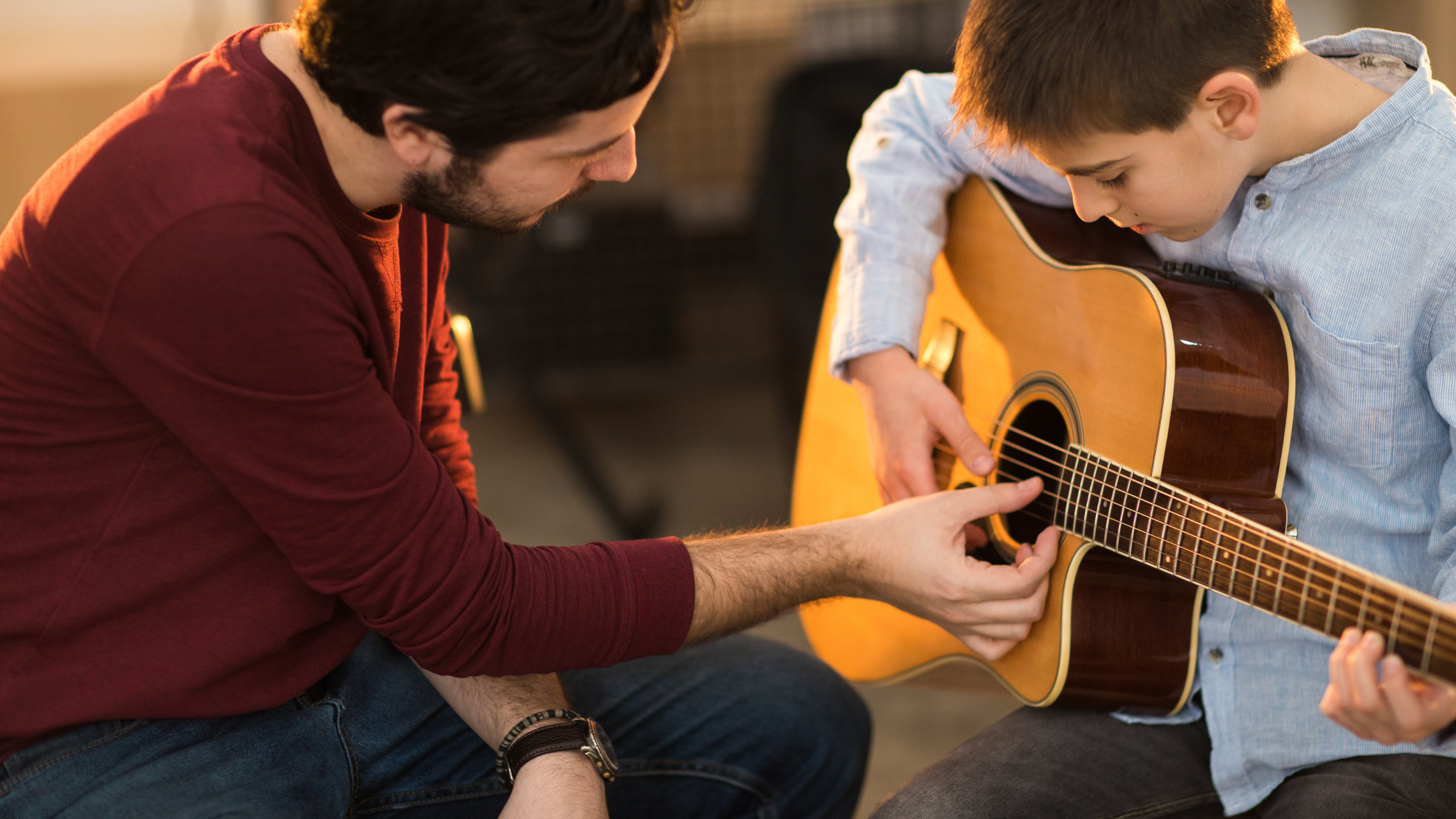 Instructor teaching a boy guitar
